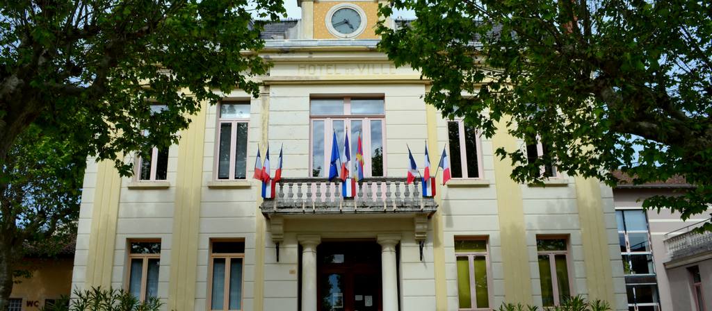Façade d'une mairie française, drapeaux tricolores au balcon