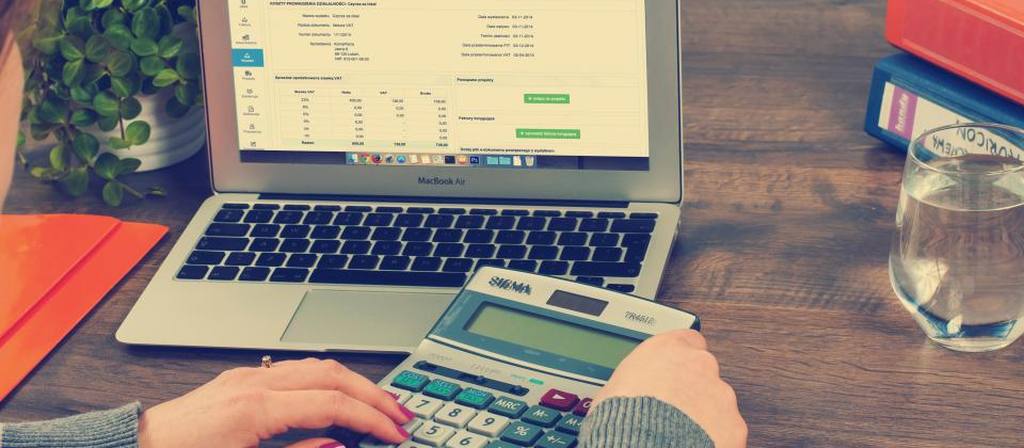 Facture affichée sur un ordinateur portable, calculatrice au premier plan